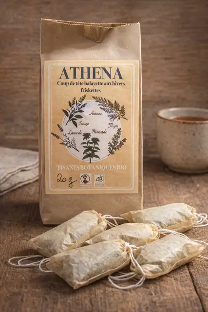 Sachet kraft de tisane botanique bio Athena, étiquette ocre illustrée de plantes et sachets d’infusion sur une table en bois.